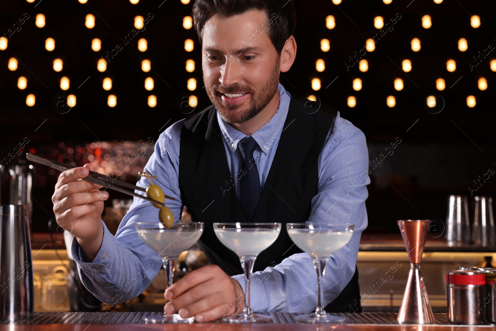 Photo of Bartender preparing fresh alcoholic cocktail in bar