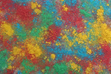 Photo of Colorful powder dyes as background, top view. Holi festival