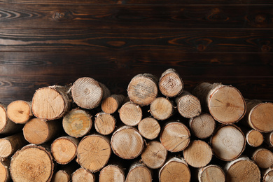Photo of Cut firewood on wooden background. Heating in winter
