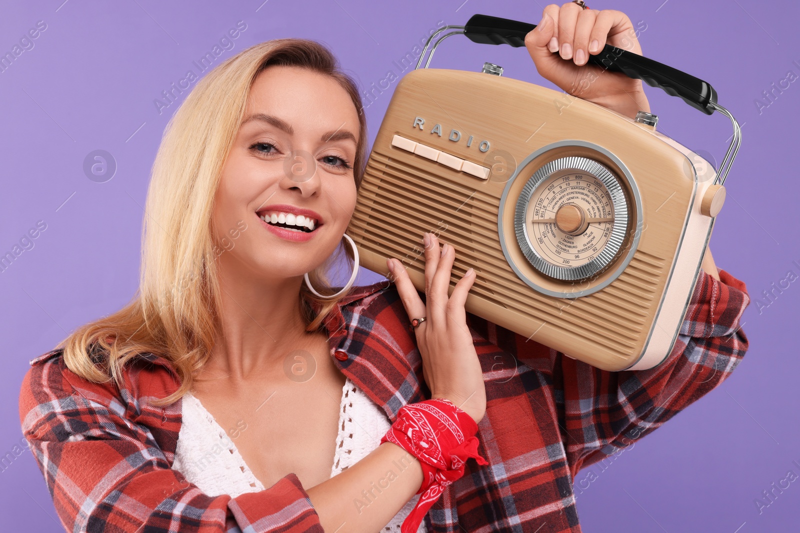 Photo of Happy hippie woman with retro radio receiver on purple background