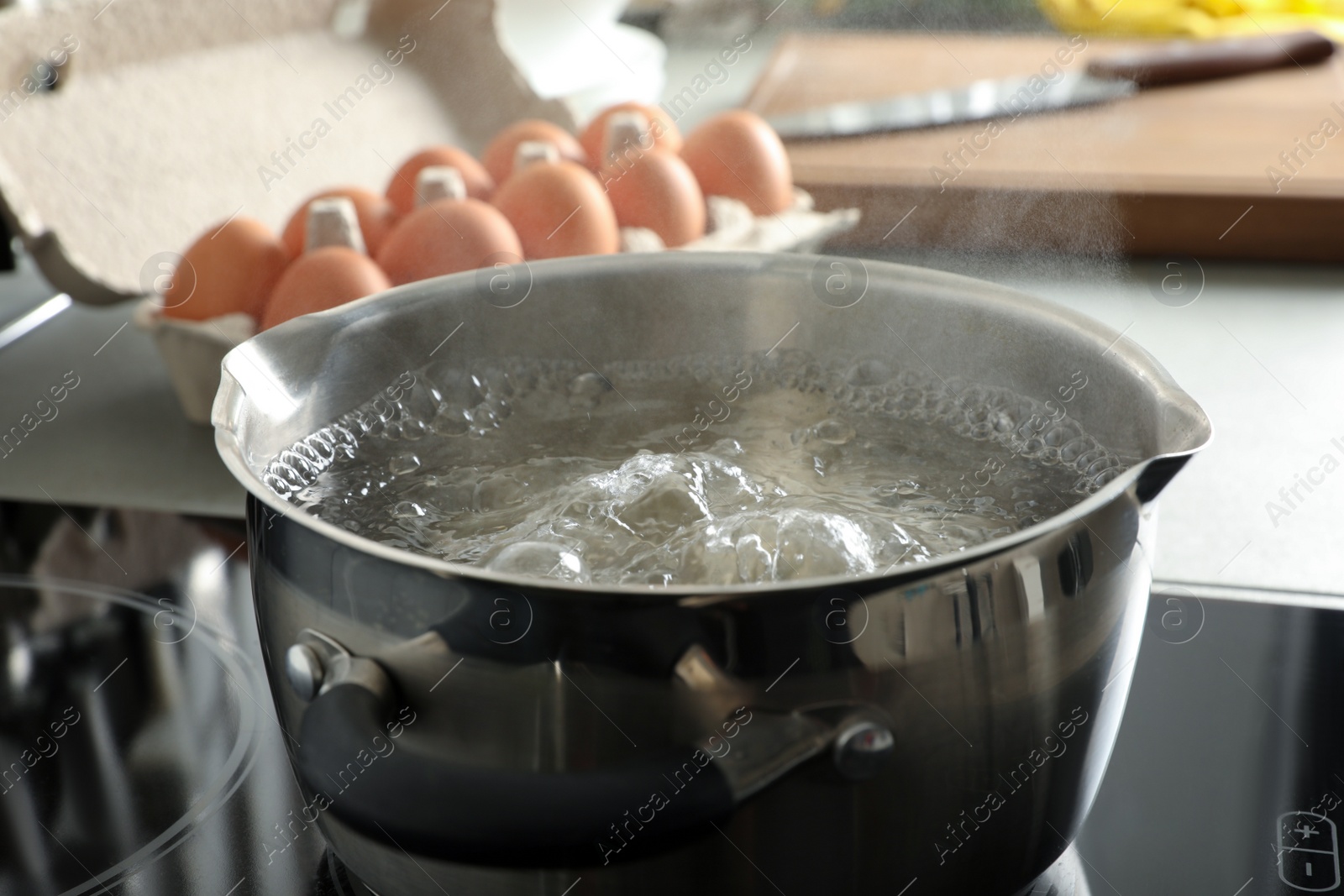 Photo of Pot with boiling water on stove, closeup