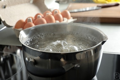 Pot with boiling water on stove, closeup