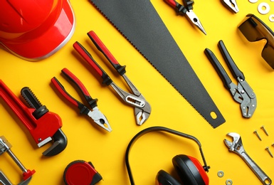 Photo of Flat lay composition with construction tools on color background