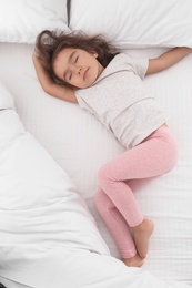 Cute little girl sleeping on cozy bed, view from above