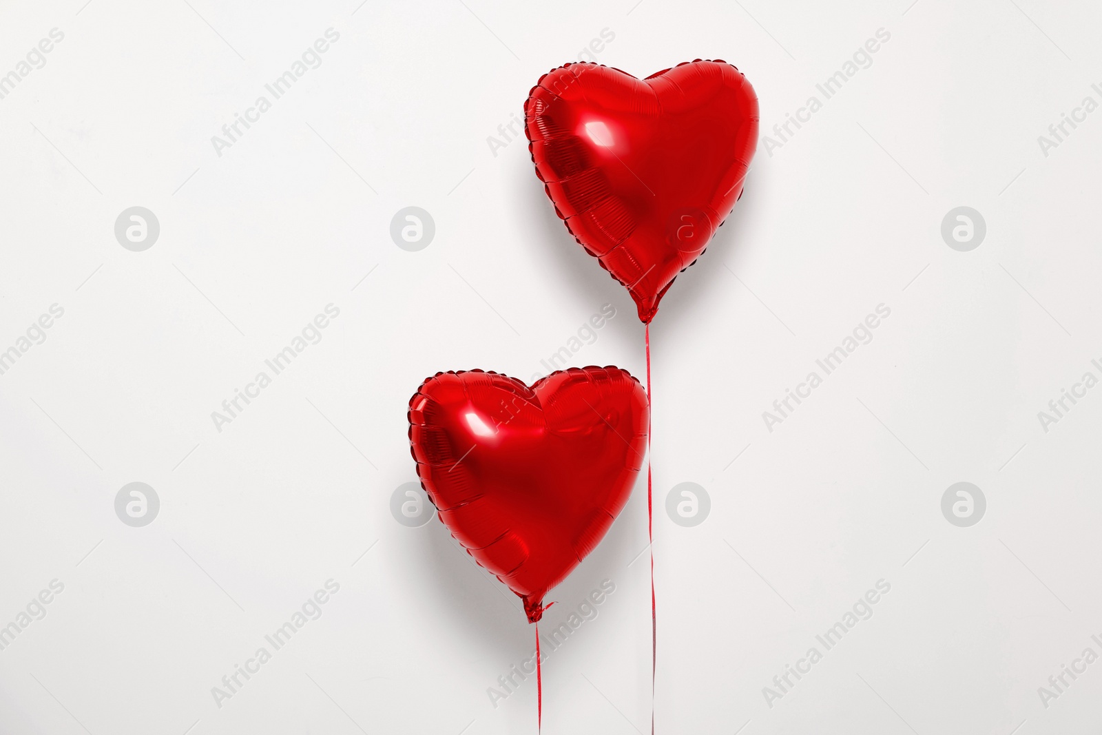 Photo of Red heart shaped balloons on white background, space for text