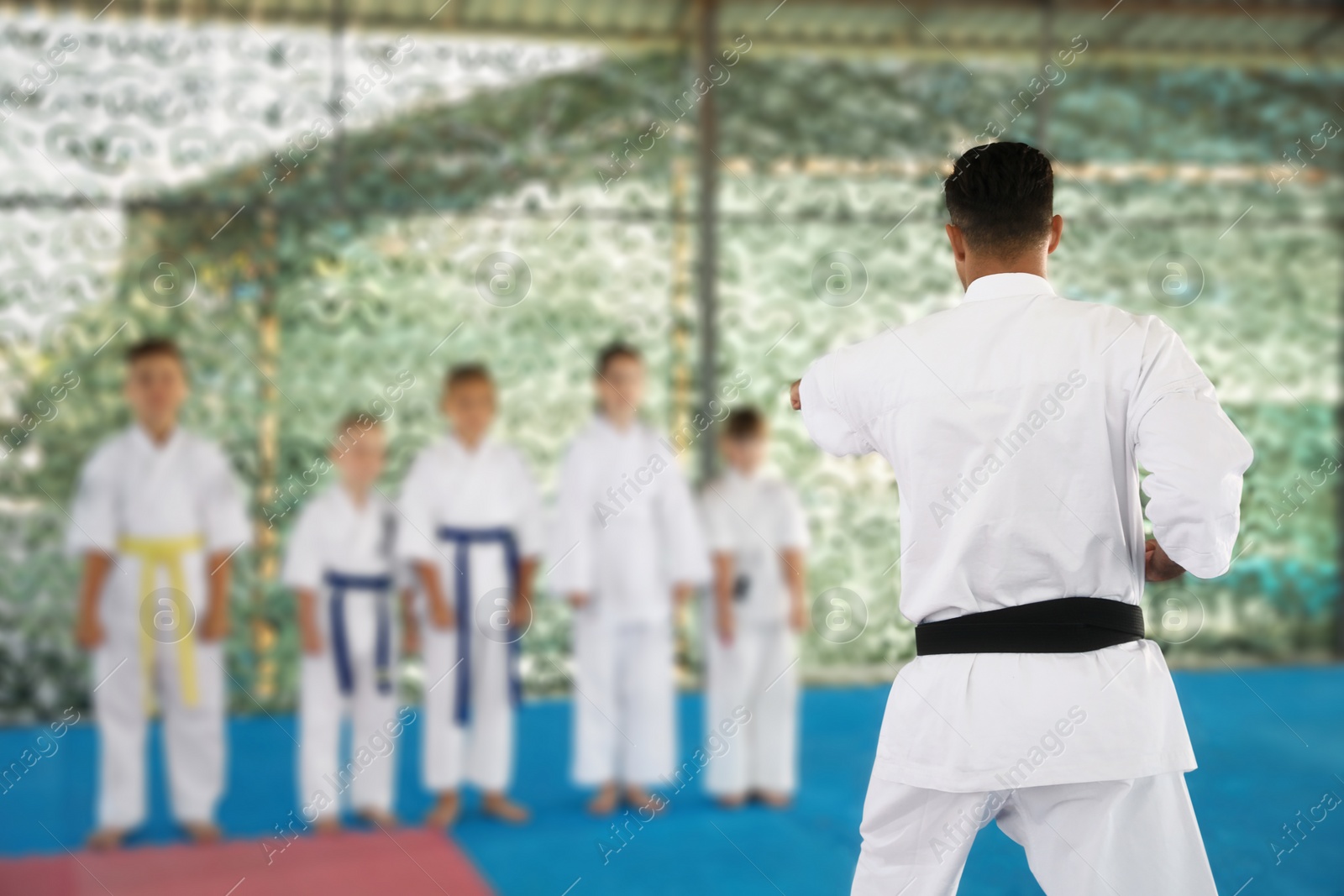 Photo of Children and coach during karate practice at outdoor gym