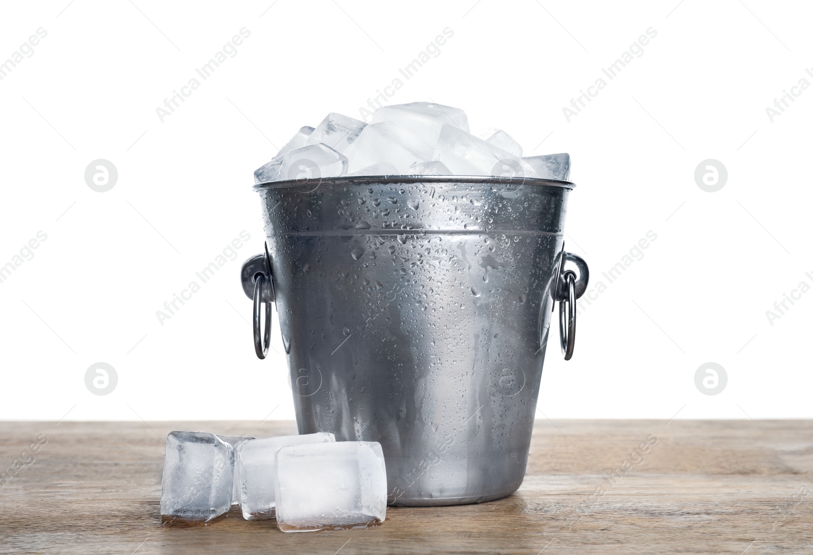 Photo of Metal bucket with ice cubes on wooden table against white background