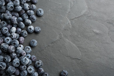 Photo of Tasty frozen blueberries on black background, flat lay. Space for text