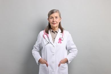 Photo of Mammologist with pink ribbon on gray background. Breast cancer awareness