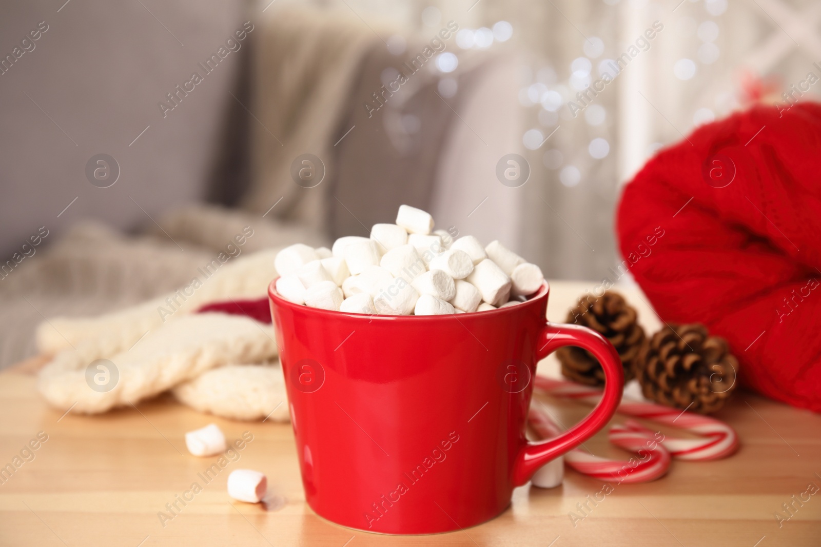 Photo of Cup of hot cocoa with marshmallows on wooden table indoors. Winter drink