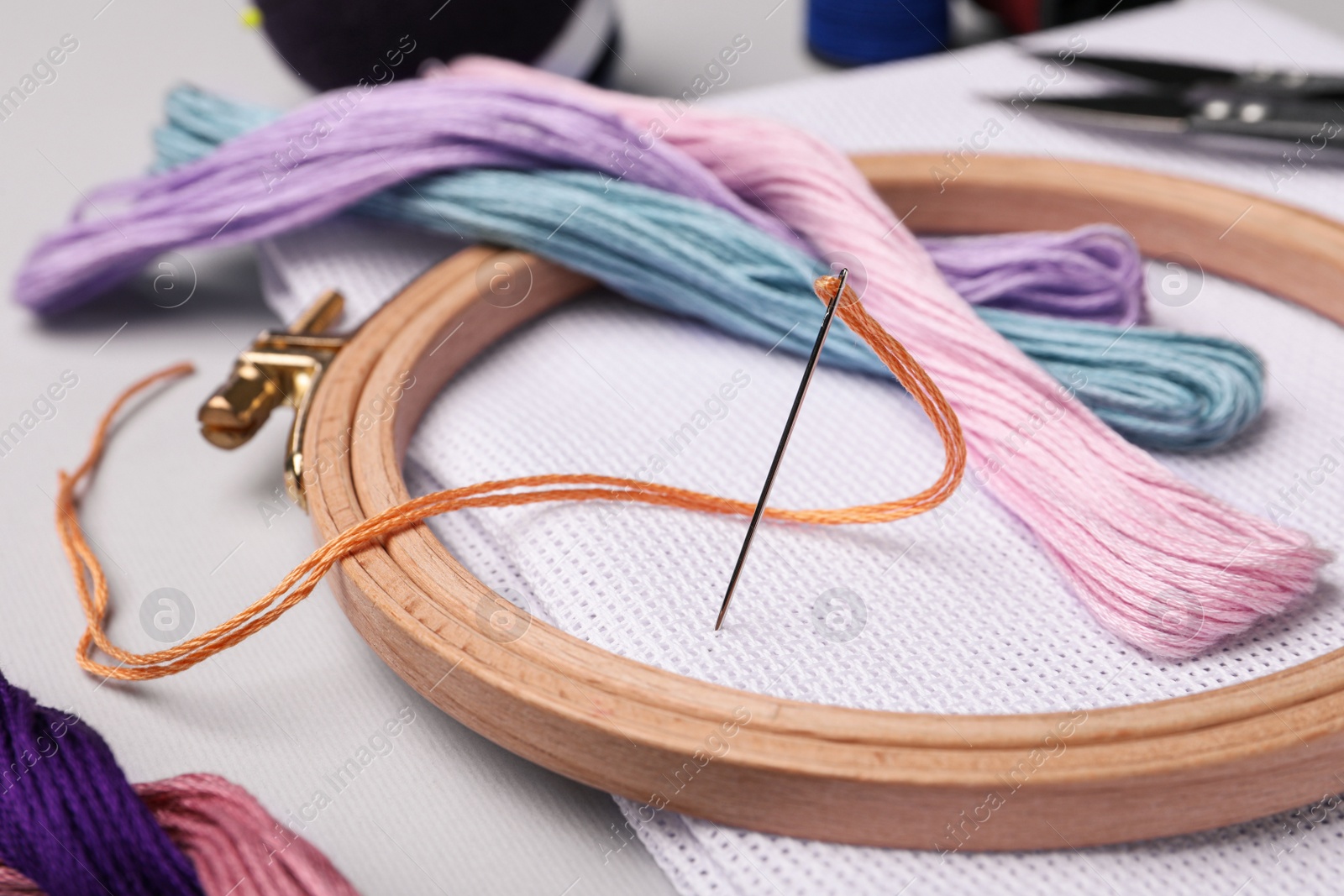 Photo of Set of embroidery equipment on light grey background, closeup