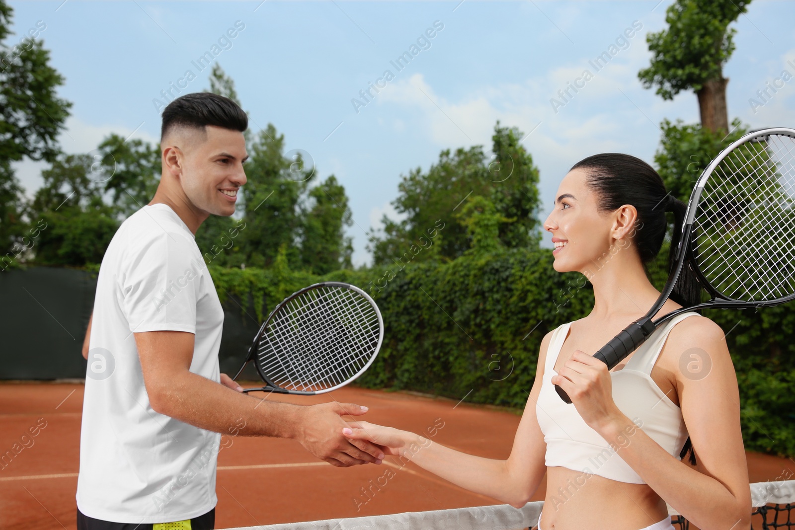 Photo of Man and woman shaking hands at tennis court