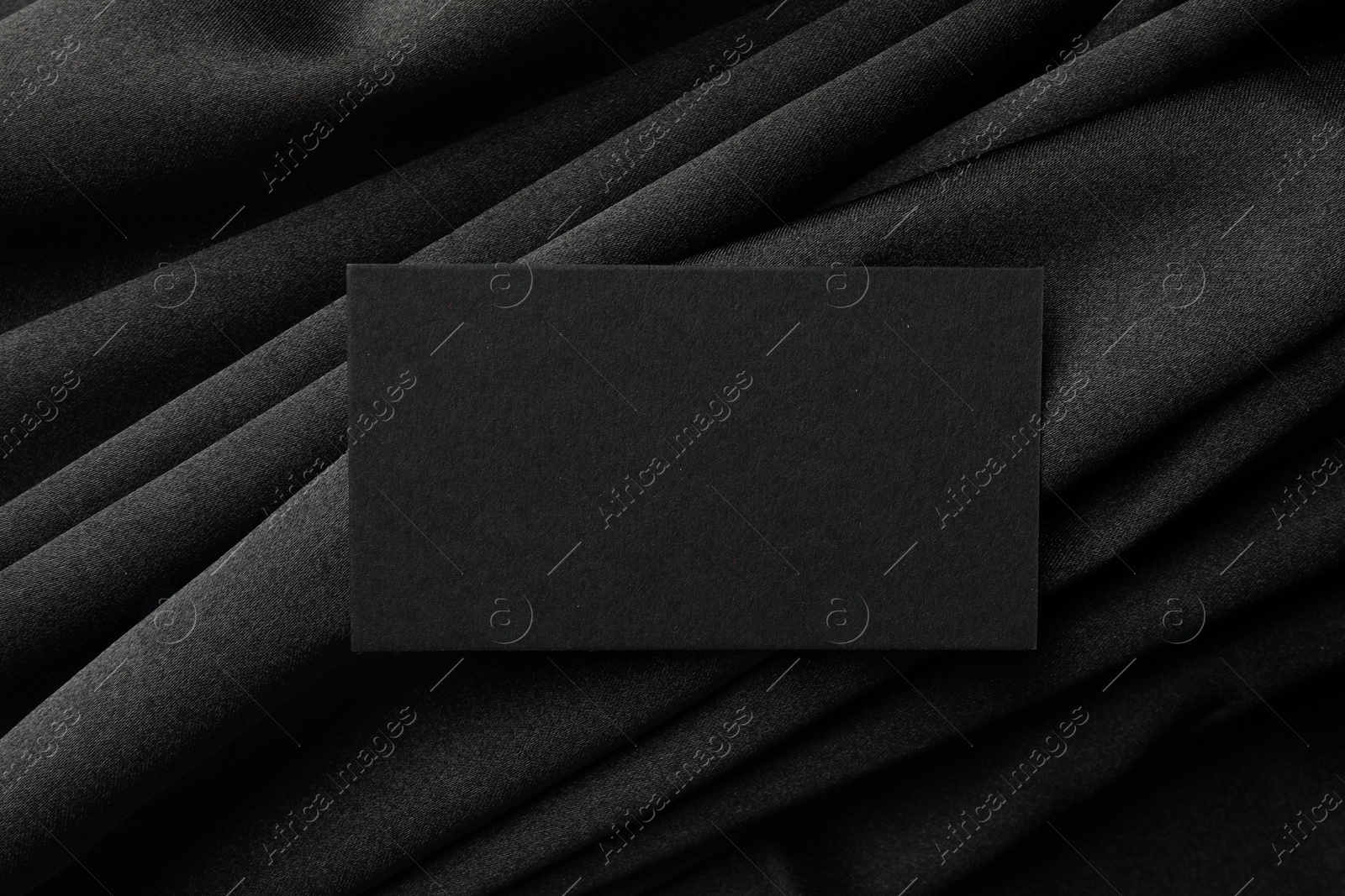 Photo of Blank business card on black fabric, top view. Mockup for design