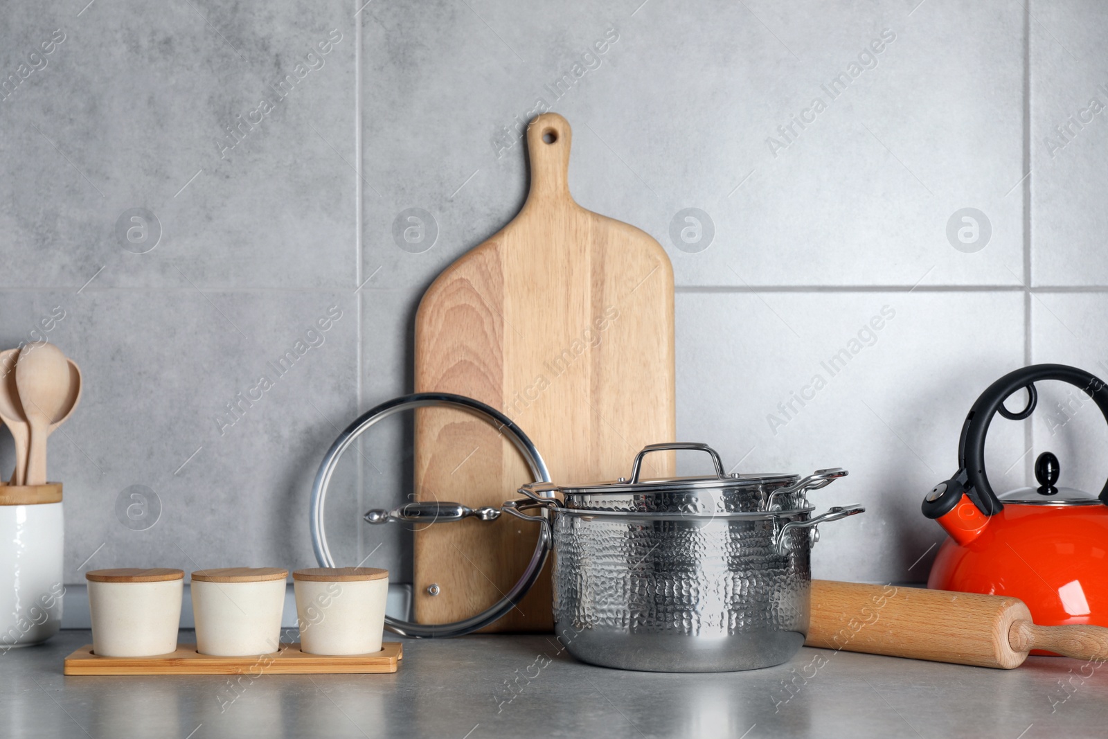 Photo of Set of different cooking utensils on grey countertop in kitchen