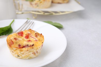 Photo of Freshly baked bacon and egg muffin with cheese on light gray table, space for text