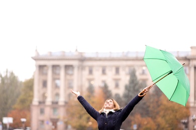 Photo of Woman with umbrella in city on autumn rainy day