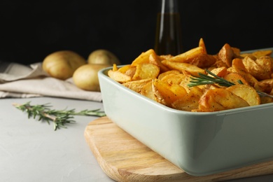 Photo of Dish of delicious oven baked potatoes on table, closeup. Space for text