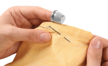 Photo of Woman sewing on yellow fabric with thimble and needle against white background, closeup