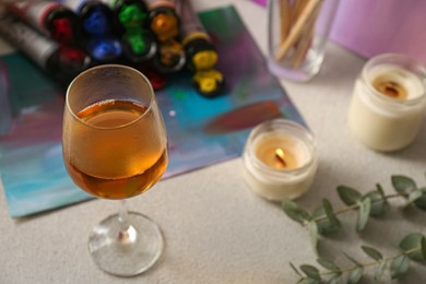 Glass of tasty wine, colorful paints and canvas, above view. Space for text