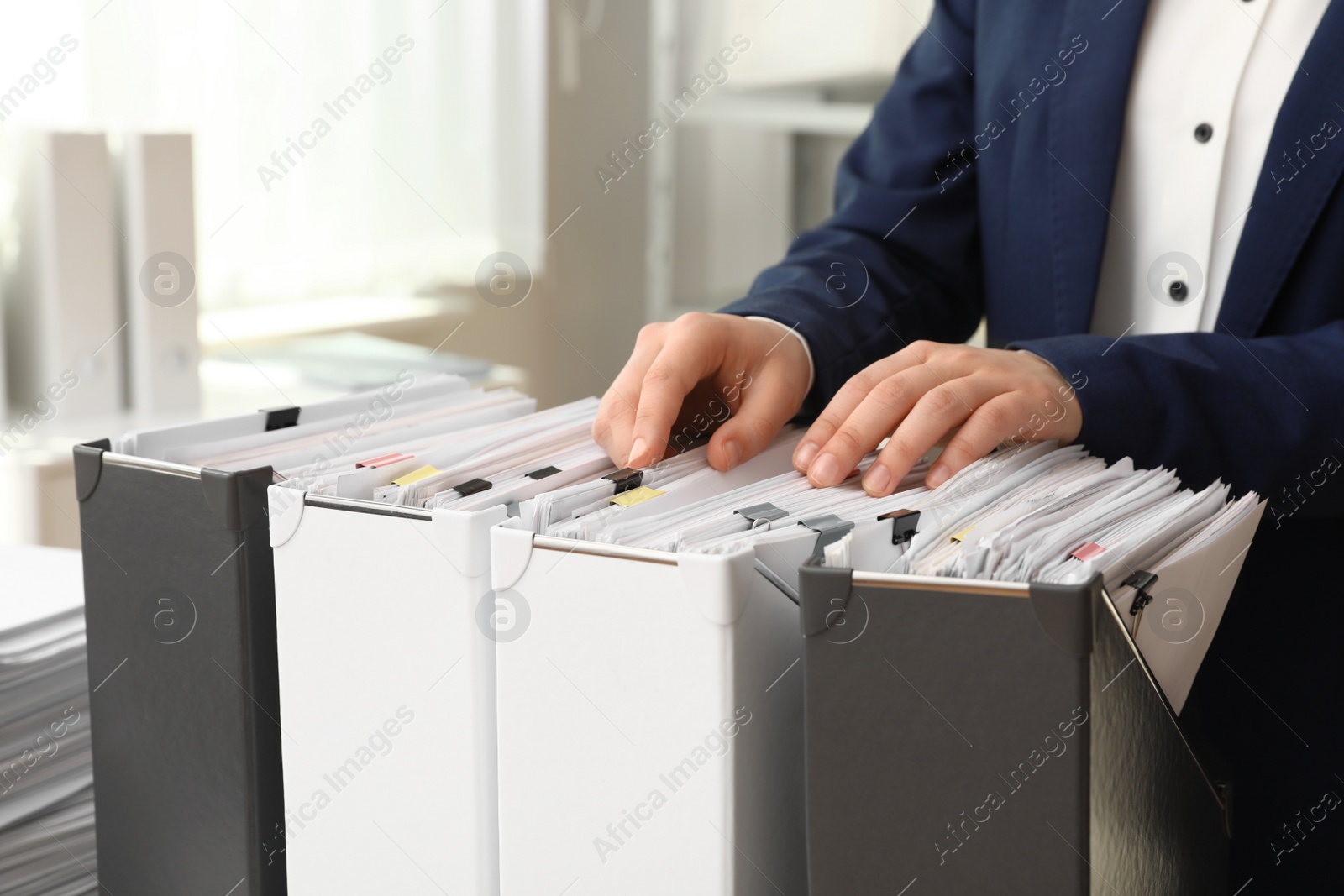 Photo of Woman taking documents from folder in archive, closeup