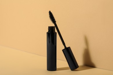 Photo of Mascara for eyelashes on beige background. Makeup product