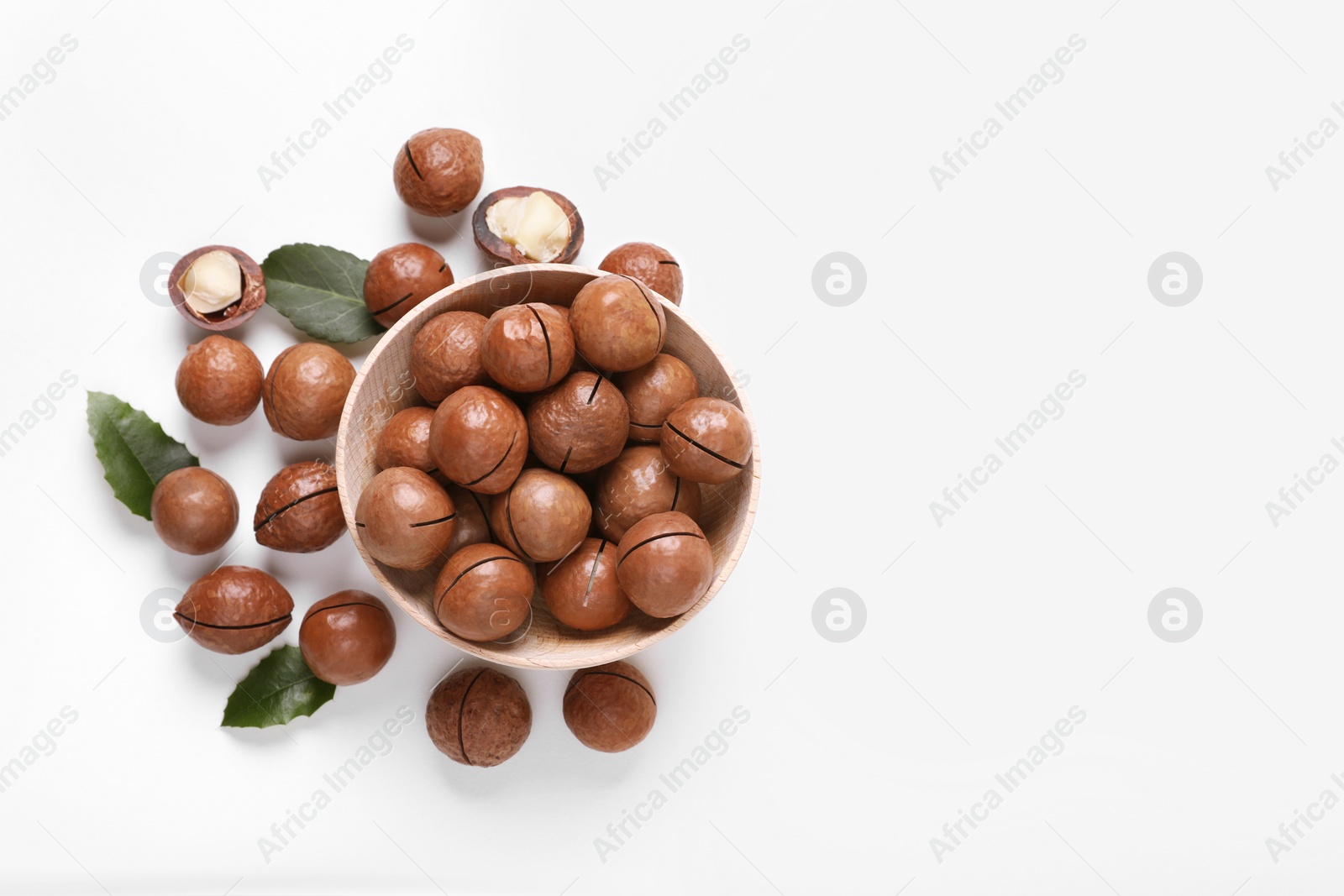 Photo of Delicious organic Macadamia nuts on white background, flat lay. Space for text