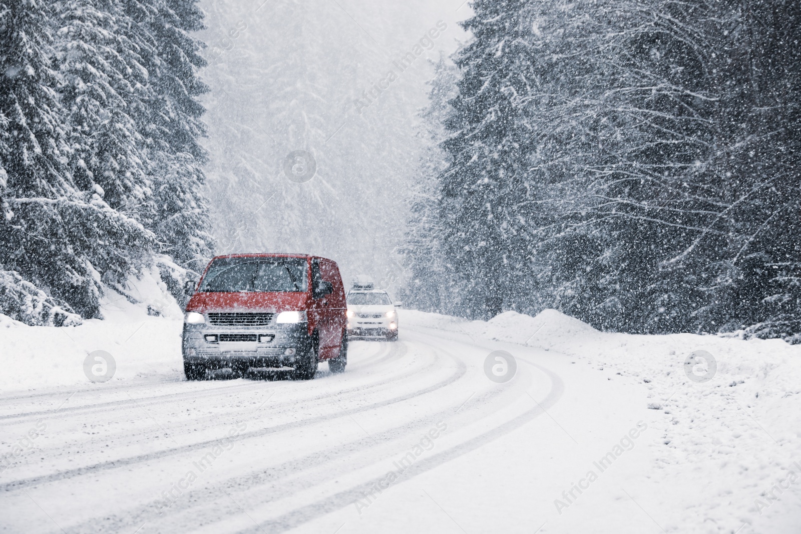 Photo of Snowy country road with modern cars on winter day