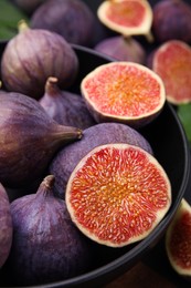 Photo of Bowl with fresh ripe figs on table, closeup