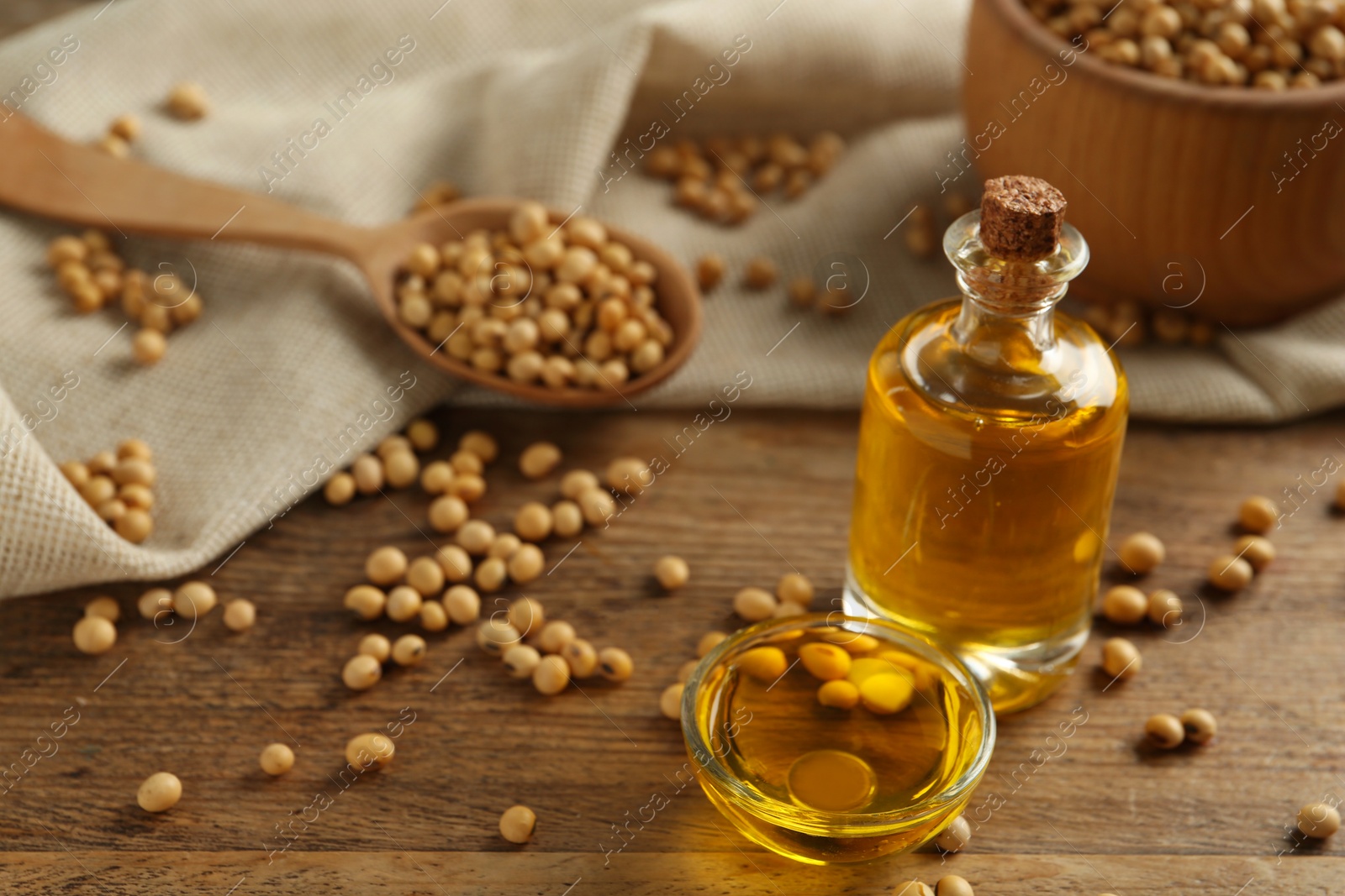 Photo of Composition with soybean oil on wooden table