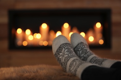 Photo of Woman relaxing on fuzzy rug against blurred background, closeup. Winter atmosphere