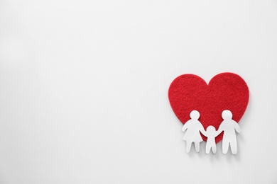 Photo of Paper silhouette of people and red heart on light background, top view