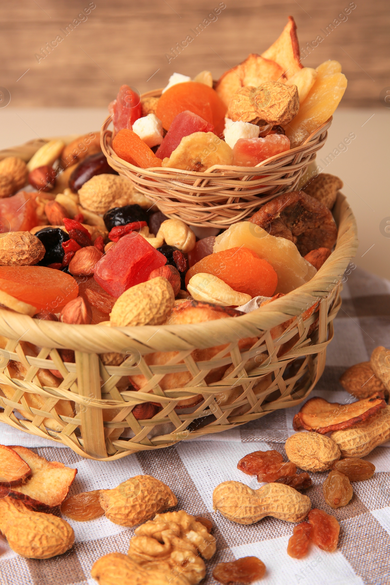 Photo of Mixed dried fruits and nuts on checkered tablecloth, closeup