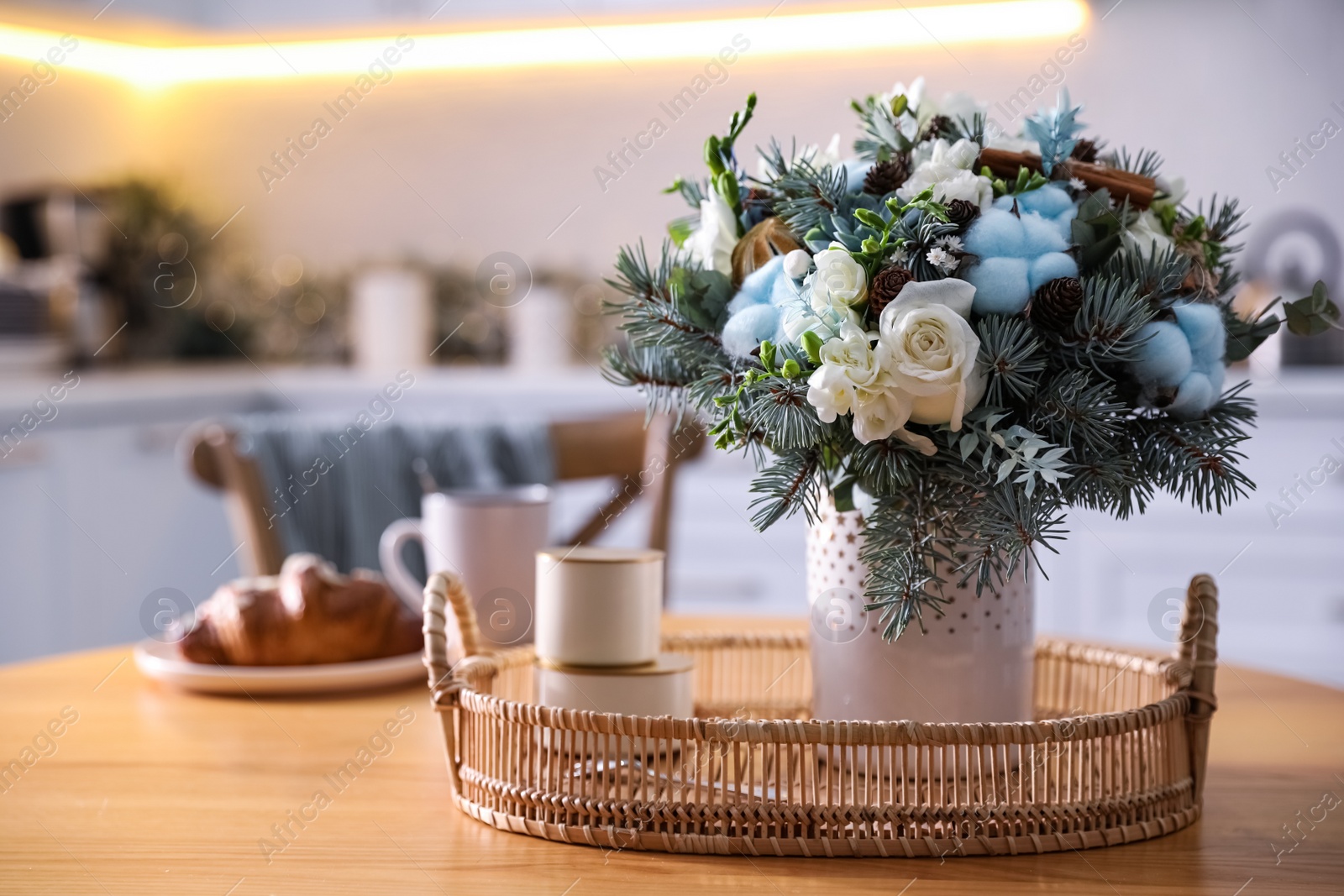 Photo of Beautiful winter bouquet on wooden table in kitchen