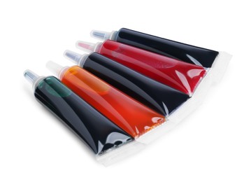 Photo of Tubes with different food coloring on white background