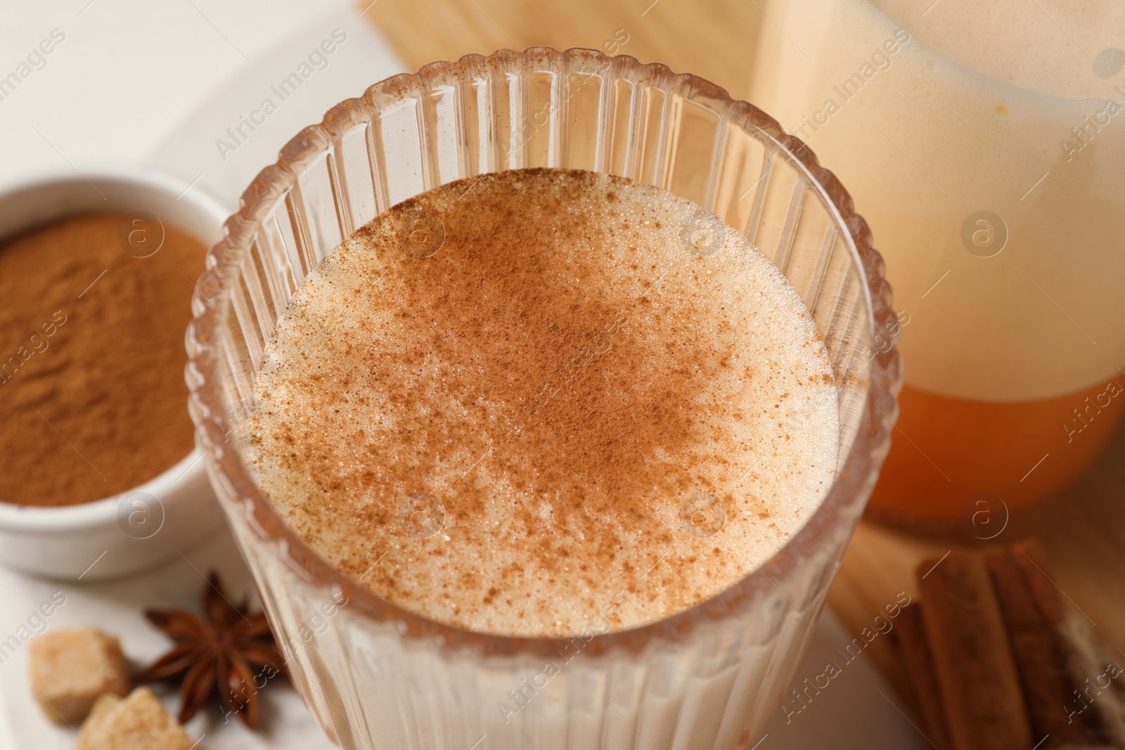 Photo of Delicious eggnog with anise on white table, closeup