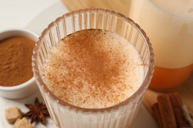Delicious eggnog with anise on white table, closeup