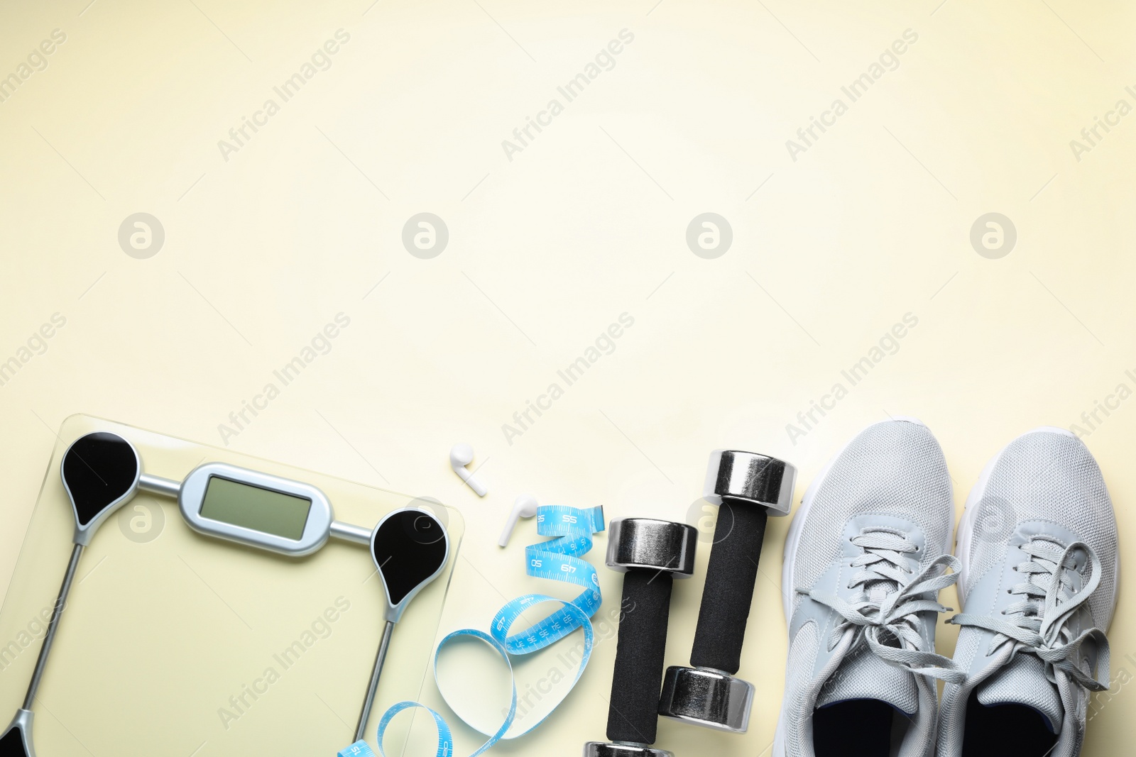 Photo of Flat lay composition with electronic scales and measuring tape on beige background, space for text