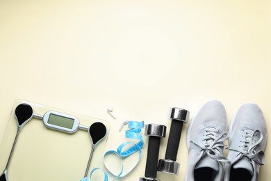 Photo of Flat lay composition with electronic scales and measuring tape on beige background, space for text