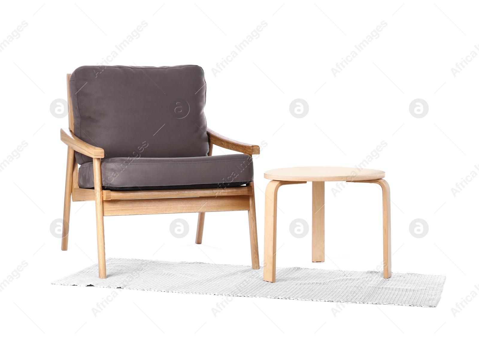 Photo of Comfortable armchair with coffee table and rug isolated on white