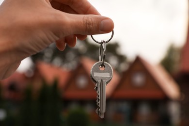 Real estate agent holding keys to new house outdoors, closeup