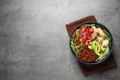 Delicious avocado salad with fried chicken on grey table, top view. Space for text