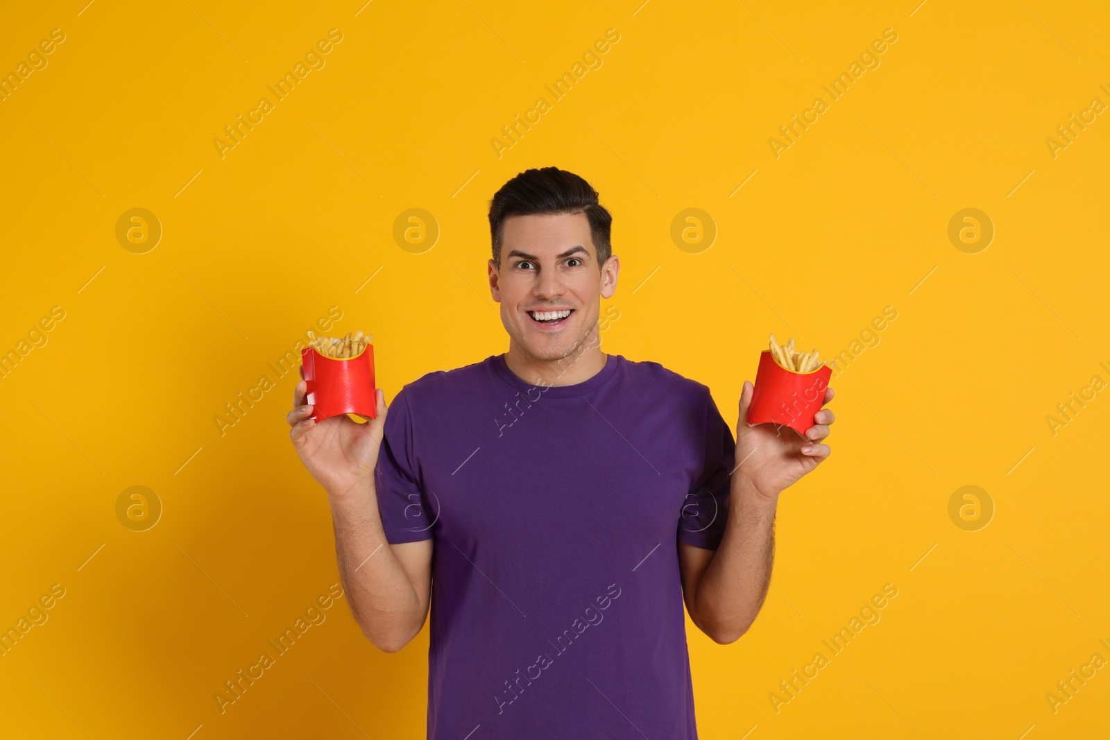 Photo of Man with French fries on orange background