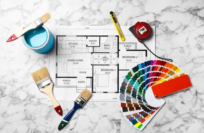 Photo of Set of decorator's tools and project drawing on light background, flat lay