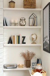 Photo of Bookends with books and decor on shelves indoors. Interior design