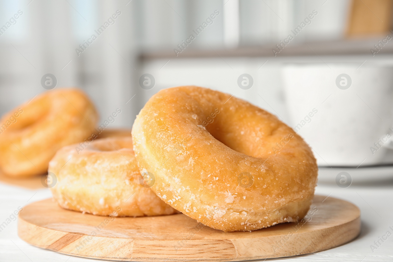 Photo of Sweet delicious donuts on white wooden table