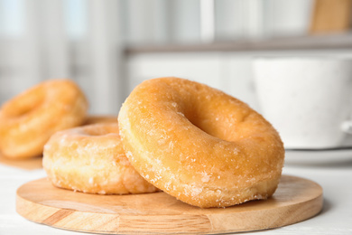 Sweet delicious donuts on white wooden table