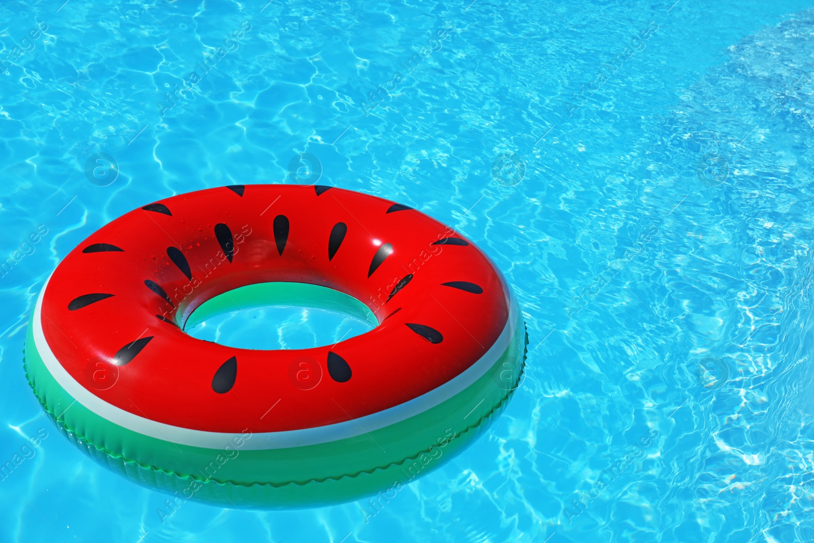 Photo of Inflatable ring floating in swimming pool on sunny day