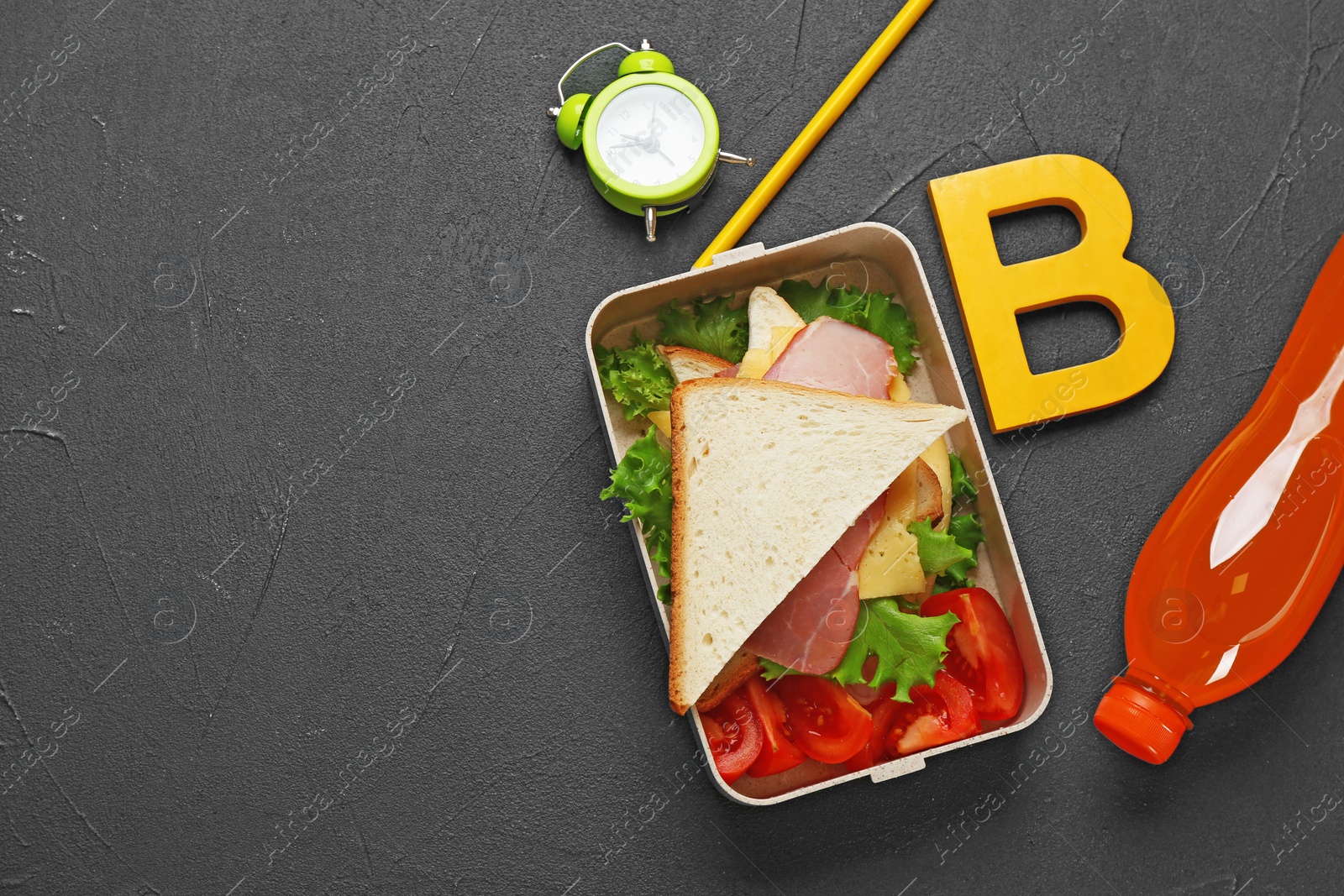 Photo of Flat lay composition with lunch box and appetizing food for school on black background