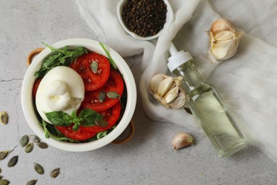 Flat lay composition with delicious burrata cheese and tomatoes on light grey table