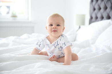 Photo of Cute little baby crawling on bed at home